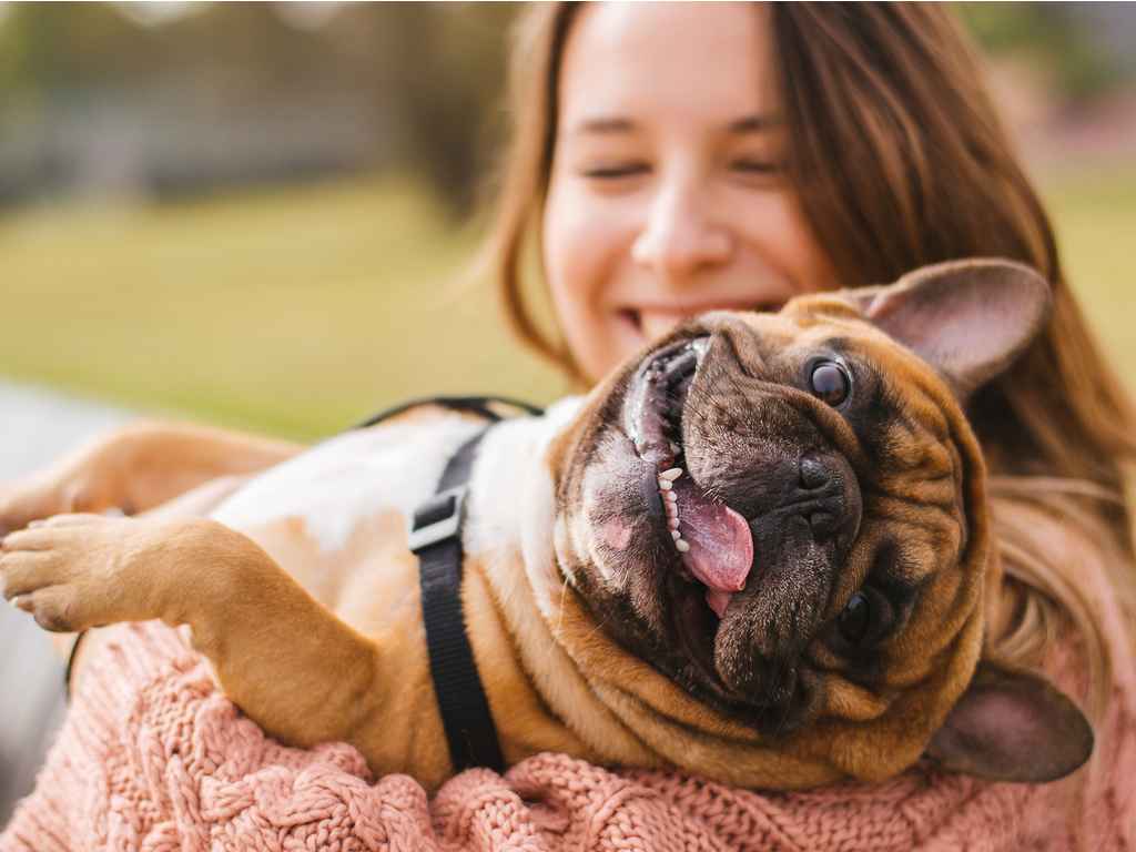 mulher feliz com um cachorro no colo